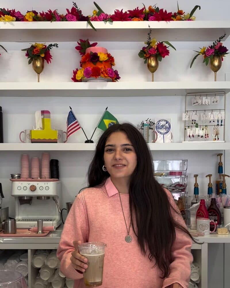 Behind the counter at Renata Café & Pastries, with the American and Brazilian flags on the shelf